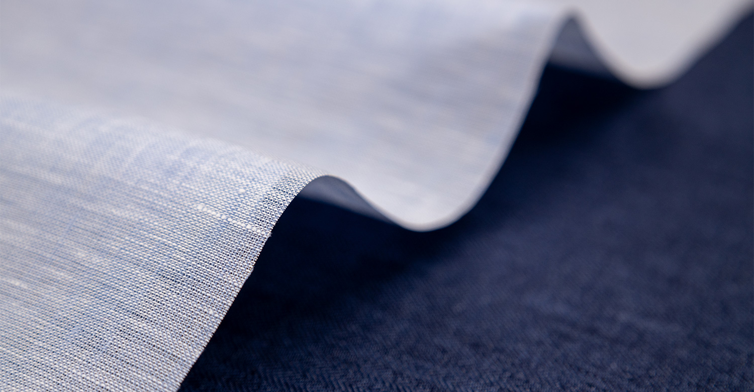 Folded twill fabric in light gray; soft grey material pressed with frayed  edge visible Stock Photo